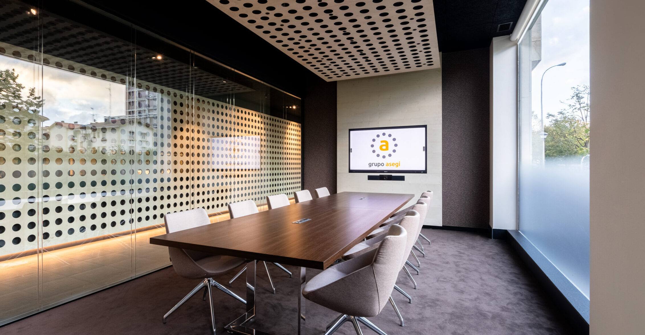 Sala de reuniones de la oficina de Grupo Asegi en Donostia, con su pantalla perforada